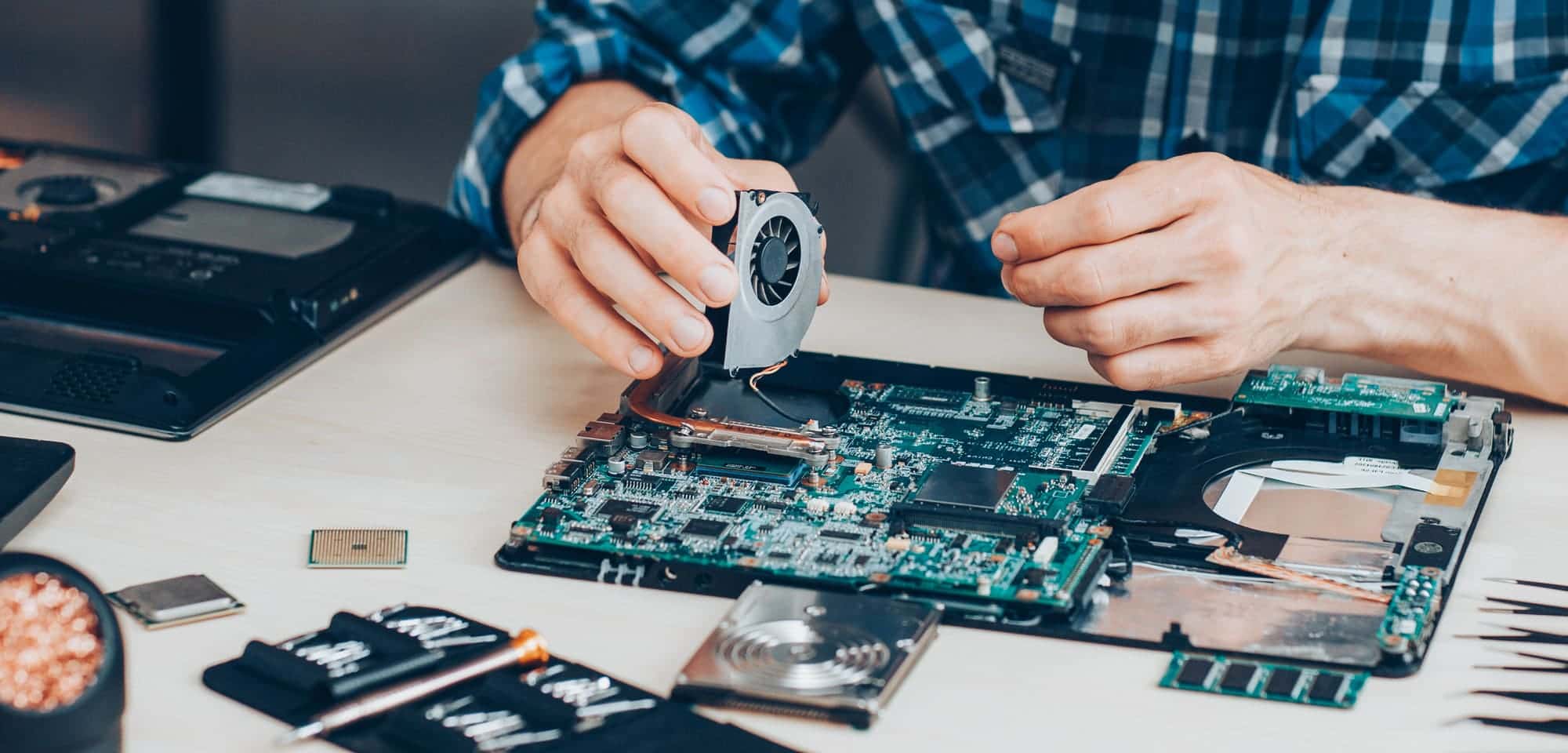 Technician repairing a laptop motherboard